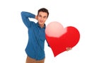 Relaxed man holding big red heart with hand behind neck Royalty Free Stock Photo