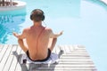 Relaxed man listening to music on headphones by the swimming pool Royalty Free Stock Photo