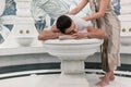 Relaxed man lying down on hot marble bed during traditional Turkish bath Royalty Free Stock Photo