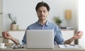 Relaxed Man Meditating Sitting At Laptop In Office