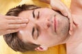 Relaxed Man Receiving Forehead Massage In Spa