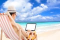 Relaxed man sitting on beach chairs and using a laptop. Royalty Free Stock Photo