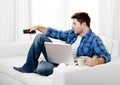 Relaxed man using Computer at home switching tv on Royalty Free Stock Photo