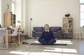 Relaxed mature man meditating in lotus pose on yoga mat on office floor