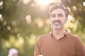 Relaxed middle-aged man looking away while standing outdoors in a park. Royalty Free Stock Photo