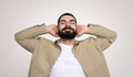 A relaxed man with a beard and a content smile leans back with his hands behind his head Royalty Free Stock Photo