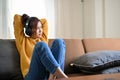 Relaxed millennial Asian woman chilling in her living room, listening to music on headphones Royalty Free Stock Photo