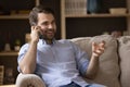 Relaxed millennial guy sitting on sofa having nice telephone conversation Royalty Free Stock Photo