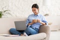 Relaxed japanese woman watching movie online, using laptop Royalty Free Stock Photo