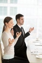 Relaxed mindful businessman and businesswoman meditating at work