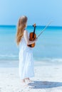 relaxed modern teenager girl in white dress on ocean coast