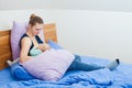 Mother feeding baby sitting on bed in the bedroom Royalty Free Stock Photo
