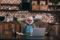 Relaxed old man in headphones using laptop with feet Royalty Free Stock Photo