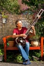 Relaxed older man is playing a sitar Royalty Free Stock Photo