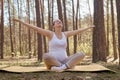 Relaxed overjoyed pregnant woman doing yoga in nature outdoors spreading hands looking at sky with overjoyed facial expression Royalty Free Stock Photo
