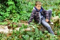 Relaxed and peaceful. Little boy relax sitting on tree. Little boy relax in woods. Relax, life is beautiful Royalty Free Stock Photo