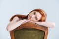 Relaxed redhead woman sitting on the chair Royalty Free Stock Photo