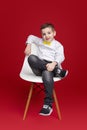 Relaxed schoolboy sitting on chair