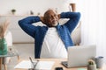 Relaxed Senior African Businessman Holding Hands Behind Head In Office Royalty Free Stock Photo