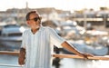 Relaxed senior man standing near luxurious yachts at the dockside Royalty Free Stock Photo