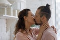 Relaxed sincere young couple kissing in kitchen, hugging with love Royalty Free Stock Photo