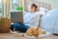 Relaxed sleeping red cat lying on floor, woman with laptop in out of focus Royalty Free Stock Photo