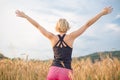 Relaxed sporty woman, arms rised, enjoying nature in the beautifull morning at wheet field. Royalty Free Stock Photo