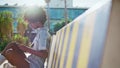 Relaxed student reading book sitting bench sunny street. African girl learning Royalty Free Stock Photo