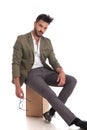 Relaxed stylish man with open collar sitting on wooden box Royalty Free Stock Photo