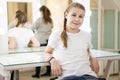 Relaxed teen girl a model sitting in dressing room after casting, mother ready to leave the studio