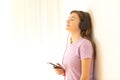 Relaxed teen listening to music on leaning a wall