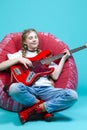 Relaxed Teenager Guitar Player With Red Shiny Bass Guitar Posing In Casual White Shirt With Smiling Facial Expression While