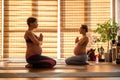 Peaceful impregnate ladies in yoga class