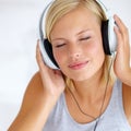 Relaxed tunes. A young woman listening to music on her headphones. Royalty Free Stock Photo