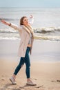 Relaxed woman, arms rised, enjoying spring sun, on a beautiful beach. Young lady feeling free, relaxed and happy Royalty Free Stock Photo