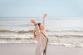 Relaxed woman, arms rised, enjoying spring sun, on a beautiful beach. Young lady feeling free, relaxed and happy Royalty Free Stock Photo