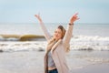 Relaxed woman, arms rised, enjoying spring sun, on a beautiful beach. Young lady feeling free, relaxed and happy Royalty Free Stock Photo