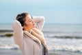 Relaxed woman, arms rised, enjoying spring sun, on a beautiful beach. Young lady feeling free, relaxed and happy Royalty Free Stock Photo