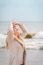 Relaxed woman, arms rised, enjoying spring sun, on a beautiful beach. Young lady feeling free, relaxed and happy Royalty Free Stock Photo