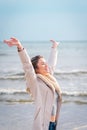 Relaxed woman, arms rised, enjoying spring sun, on a beautiful beach. Young lady feeling free, relaxed and happy Royalty Free Stock Photo