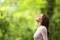 Relaxed woman breathing fresh air in a green forest