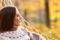 Relaxed woman contemplating on hammock in autumn