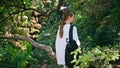 Relaxed woman contemplating nature park walking near green trees with backpack.