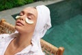 Relaxed Woman With Cucumber Mask. Bathrobe Girl Relaxing Near Swimming Pool