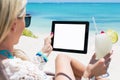 Relaxed woman drinking cocktail and holding tablet computer on the beach Royalty Free Stock Photo