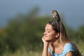 Relaxed woman enjoying nature with an owl on head