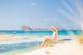 Woman reading book, enjoying sun on beach. Royalty Free Stock Photo