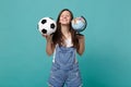 Relaxed woman football fan cheer up support favorite team with soccer ball, Earth world globe isolated on blue turquoise