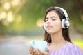 Relaxed woman with headphone meditating holding tea cup Royalty Free Stock Photo