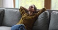 Relaxed woman lean on sofa cushions resting alone at home